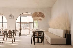 a restaurant with tables and chairs and a couch at Philosophy of Mykonos in Glastros