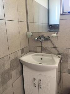 ein Badezimmer mit einem weißen Waschbecken und einem Spiegel in der Unterkunft Goritsa holiday - Karadere beach in Goritsa