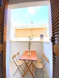 una mesa y sillas en una habitación pequeña con ventana en Casa Vacanze Patrizia, en Botrugno