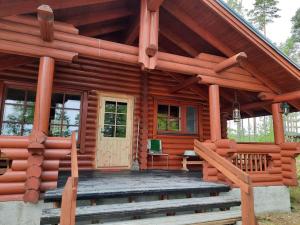 a log cabin with a porch and a front door at Lomamökki Haapajärven rannalla in Jyrkkä