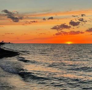 una puesta de sol sobre el océano con la puesta de sol en Яхта, en Zhanalyk