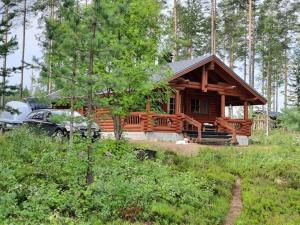 a log cabin with a car parked in front of it at Lomamökki Haapajärven rannalla in Jyrkkä