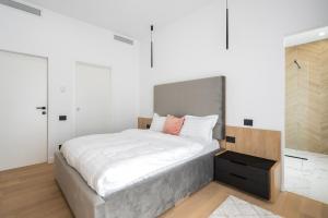 um quarto com uma cama grande e lençóis brancos em Eden I Rosetty Luxury I Moșilor em Bucareste