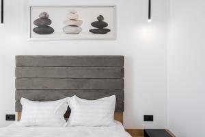 um quarto com uma cama com uma cabeceira cinzenta em Eden I Rosetty Luxury I Moșilor em Bucareste