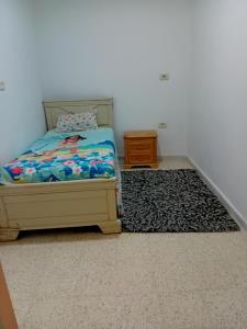 um quarto com uma cama e um tapete em Asma em Houmt Souk