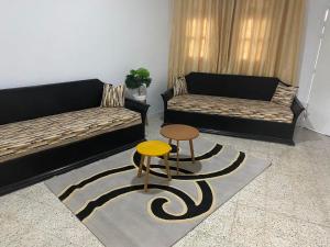 uma sala de estar com dois sofás e um banco em Asma em Houmt Souk