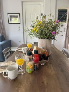 a wooden table with a vase of flowers and drinks at Ion villa - Xirokampi in Ayiá