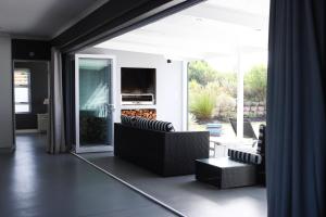 sala de estar con sofás, TV y patio en Ocean View - The House, en Knysna