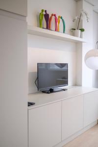 uma sala de estar com uma televisão num armário branco em Beau studio dans le Centre de Bruxelles em Bruxelas