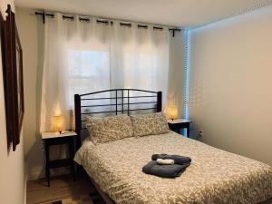 a bedroom with a bed with two lamps on it at Serene Cottage in Halifax