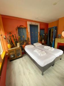 - une chambre avec un grand lit aux murs orange dans l'établissement Stee in Stad, à Groningue