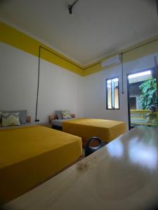 a hotel room with two beds and a window at Banana Homestay in Banyuwangi