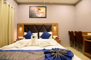 a bedroom with a large bed with blue pillows at Click Hotel Guwahati in Guwahati