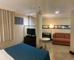 Habitación de hotel con cama y sofá en Charmoso Flat na Alameda Santos, en São Paulo