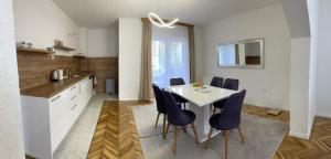 a kitchen and dining room with a white table and chairs at BORIĆI in Bihać