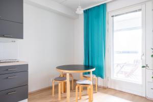 eine kleine Küche mit einem Tisch und 2 Hockern in der Unterkunft Center located apartment close to University in Tampere