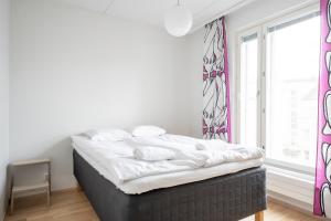 Bett in einem Zimmer mit einem großen Fenster in der Unterkunft Center located apartment close to University in Tampere