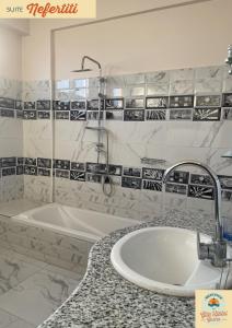 a bathroom with a sink and a bath tub at Gîte Hôtel Ramla Louxor 2 in Luxor +53 photos
