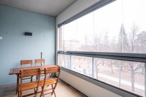 2 Stühle und ein Holztisch in einem Zimmer mit einem großen Fenster in der Unterkunft Center located apartment close to University in Tampere