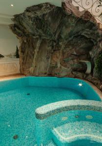 a swimming pool in a room with a rock wall at Hotel Tonnerhof in Racines
