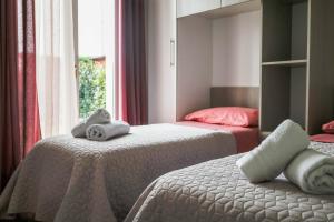 ein Schlafzimmer mit 2 Betten und Handtüchern darauf in der Unterkunft Casa di Lulù (lago e Spiaggia) in Manerba del Garda