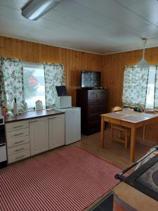 cocina con encimera, mesa y ventanas en Riverside Restplace, en Tornio