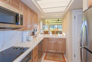 a large kitchen with wooden cabinets and a microwave at 2511 Ridge in Kahana