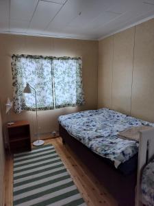 sypialnia z łóżkiem, oknem i dywanem w obiekcie Riverside Restplace w mieście Tornio