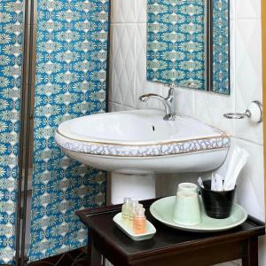 a bathroom with a sink and a mirror on a table at Bee Friend Boutique Guesthouse in Chiang Mai