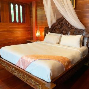 a bedroom with a large bed with a canopy at Bee Friend Boutique Guesthouse in Chiang Mai