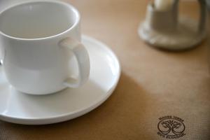 a white coffee cup on a plate on a table at Recinatum 1296 in Recanati