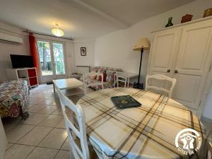 een kamer met een tafel en stoelen en een woonkamer bij La Villa Blanche - 2 personnes in Saint-Jean-de-Fos