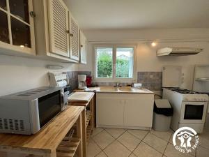 een keuken met een magnetron en een wastafel bij La Villa Blanche - 2 personnes in Saint-Jean-de-Fos