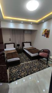 um quarto de hotel com duas camas num quarto em فندق أجياد Agyad Hotel em Assiut