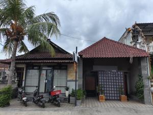 a house with motorcycles parked in front of it at Ega S Hostel in Nusa Penida