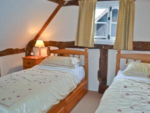 um quarto com 2 camas e uma janela em Bank Cottage em Boraston