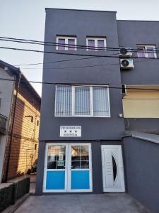 斯梅代雷沃的住宿－ViP PRENOCISTE 026，一座建筑,上面有蓝色的门和标志
