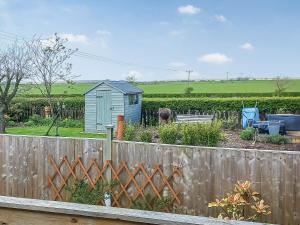 a garden with a fence and a small shed at Limewood Lodge in Kingthorpe