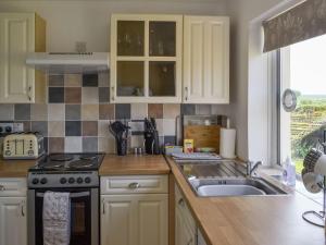 a kitchen with a sink and a stove top oven at Limewood Lodge in Kingthorpe
