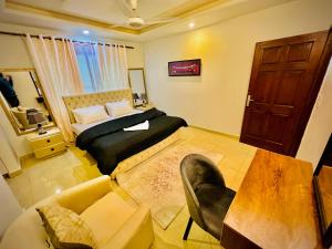 ein Schlafzimmer mit einem Bett, einem Sofa und einem Tisch in der Unterkunft Luxe and Family-friendly 2BHK in Islamabad