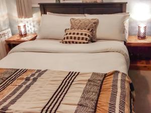 a bed with two pillows on it with two lamps at The Annex Cottage in Weymouth