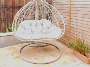 une balancelle blanche assise sur une terrasse dans l'établissement The Annex Cottage, à Weymouth