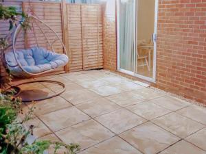 un patio con una silla y una puerta de cristal en The Annex Cottage en Weymouth