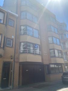 克諾克－海斯特的住宿－Tof en ruim appartement in Heist-Aan-Zee!，街道上高大的砖砌建筑,设有阳台