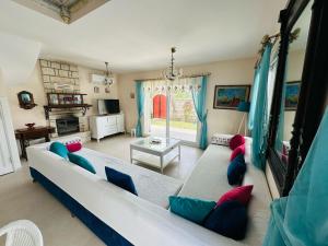 a living room with a white couch with colorful pillows at Evalacati - Villa Palma-Tamamen Müstakil Villa in Cesme
