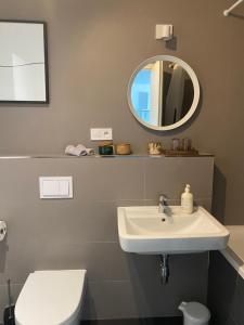 een badkamer met een wastafel, een toilet en een spiegel bij Apartman pri Radnici in Košice