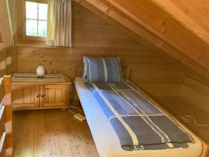 a bed in a log cabin with a window at Fravgia veglia in Andeer