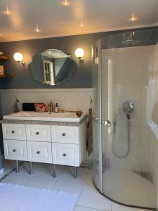 bagno con lavandino e doccia con specchio di Harbour House a Hornbæk
