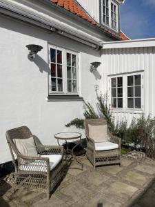 due sedie e un tavolo di fronte a una casa di Harbour House a Hornbæk