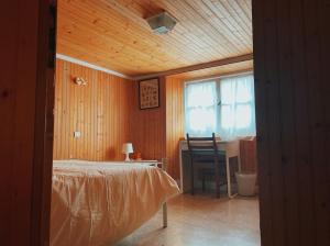 1 dormitorio con cama, escritorio y ventana en Casa Maitö, en Senarega